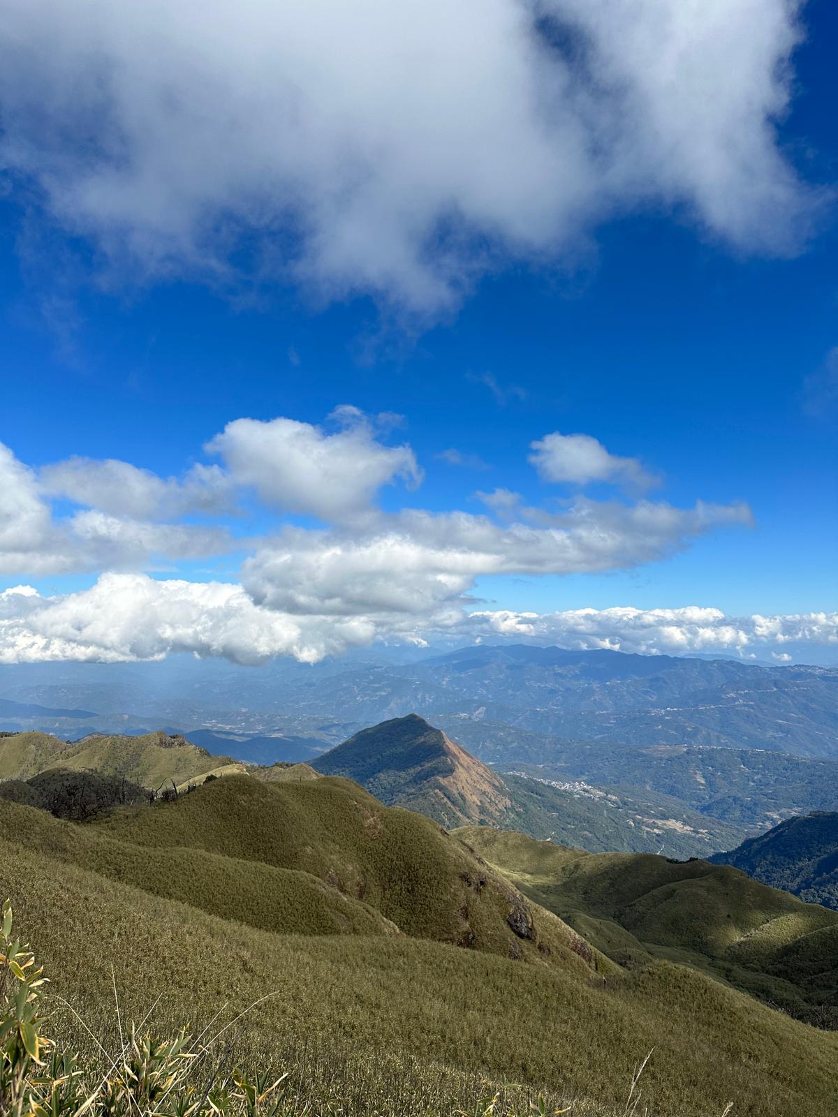Mt. Teyozwü rising as a sharp peak above the grassland slopes, seen from the summit of Mt. Tempü
