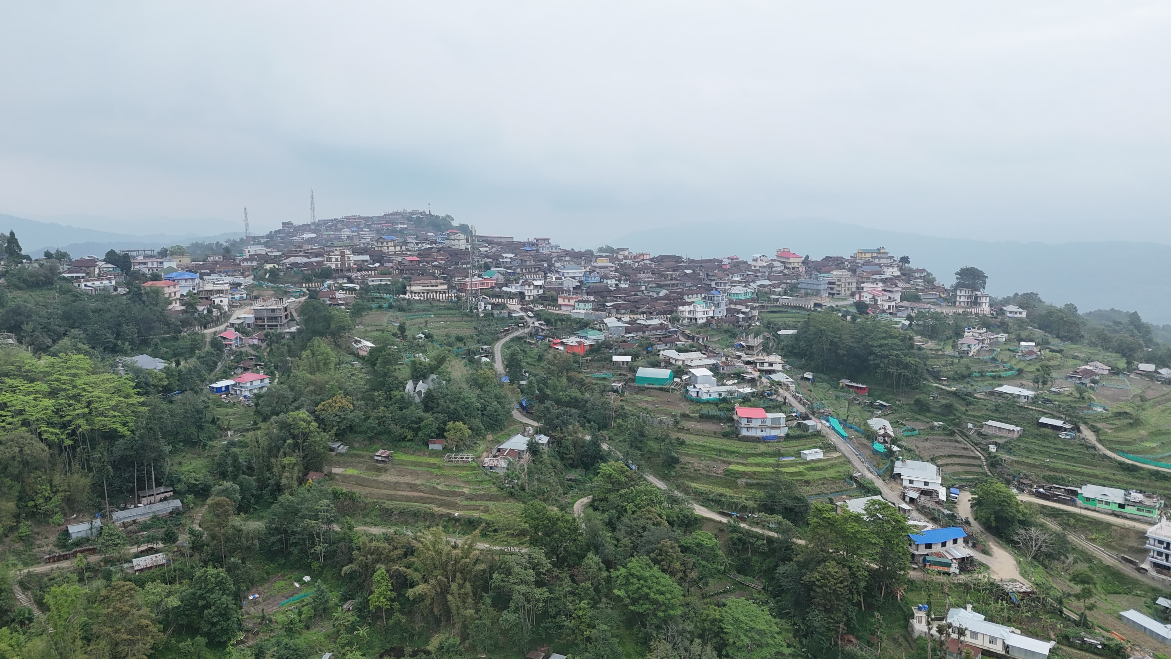 Viswema village seen in profile from a neighbouring slope, the ridge silhouetted against the hills